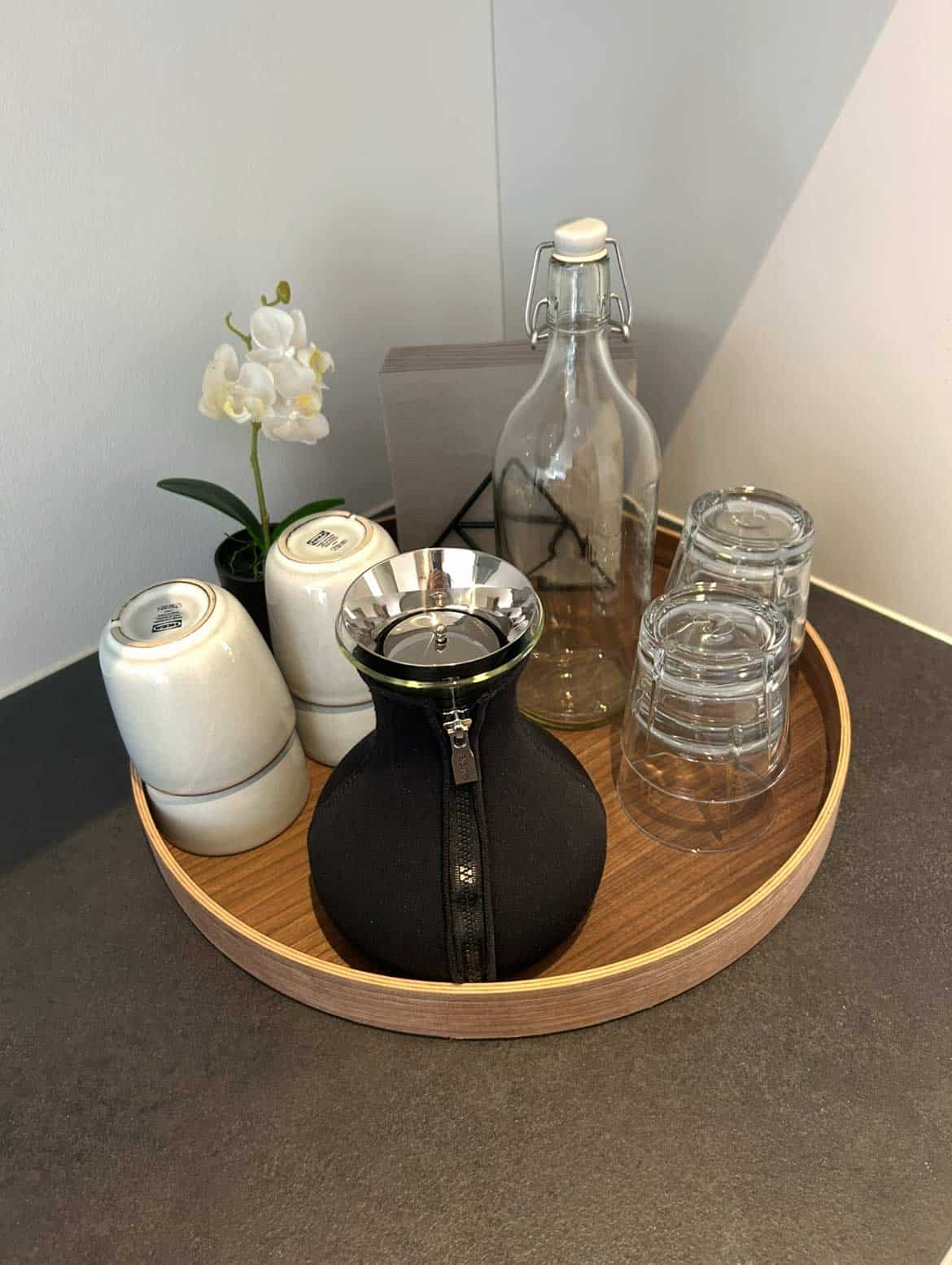 Detalje fra praksissen med orkidé, vandkaraffel og glas